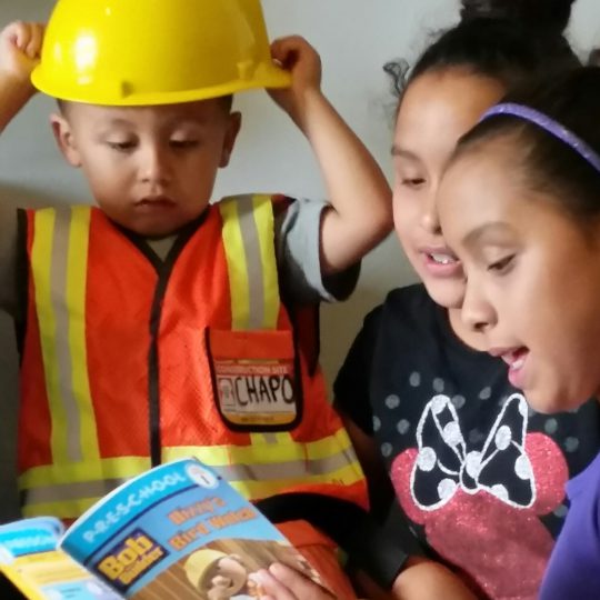 Boy with yellow helmet listening to his sisters.