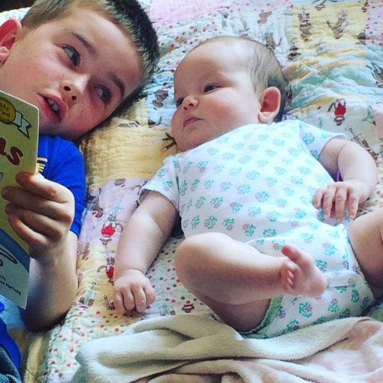 Photo of Scottie reading to his sibling